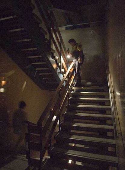 Un guardia urbano ilumina una escalera del hospital.