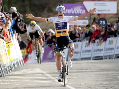 Evenepoel alza los brazos antes de cruzar la línea de meta de La Molina por delante de Roglic.