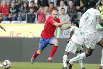 Iniesta, rodeado de contrarios, da un pase durante el partido contra Arabia Saudí.