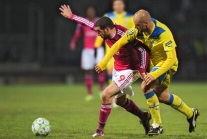 Lisandro López y Paulo Jorge luchan por el balón