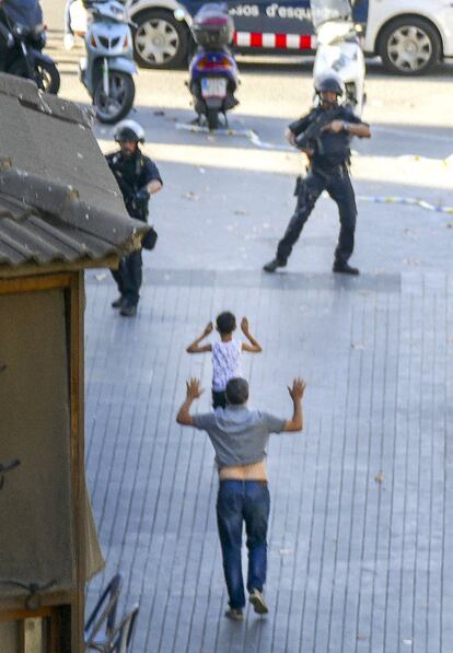 Dos personas, con los brazos en alto, salen del restaurante la Luna de Estambul en el que la policía creía que se habían refugiado algunos de los terroristas de la Rambla.