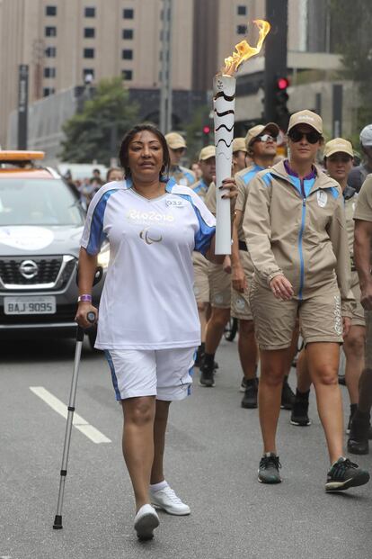 Atleta paralímpica carrega a tocha na avenida Paulista.