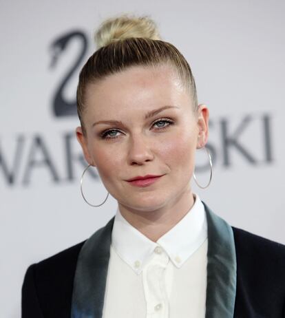 La actriz Kirsten Dunst, vestida con un esmóquin negro de solapas verdes, a su llegada a los premios CFDA.