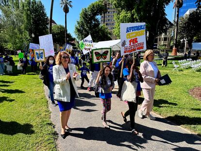 California Assembly Majority Leader Eloise Gomez Reyes, left, and Democratic Assemblymember Cecilia Aguiar-Curry, right, march with parents in California