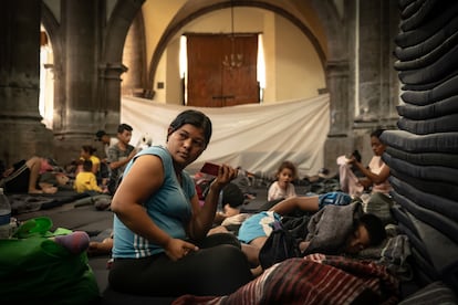 A group of Venezuelan migrants rests on mats distributed inside the parish.