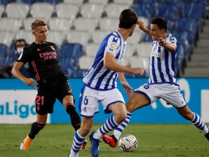 Odegaard (i) pelea un balón ante Elustondo.