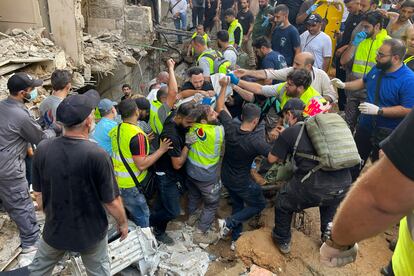 Un grupo de hombres rescatan un cadáver tras el ataque al sur de Beirut, este viernes.