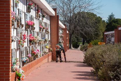 Un operario retira las hojas y la suciedad en la parte de los nichos del Cementerio Sur, en Carabanchel.