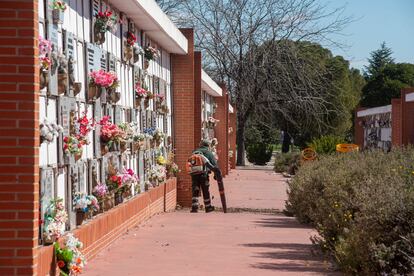 Un operario retira las hojas y la suciedad en la parte de los nichos del Cementerio Sur, en Carabanchel. 