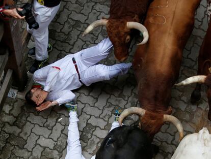 Un corredor cae al suelo durante el encierro. 