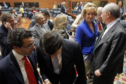 Esperanza Aguirre habla con Rodrigo Rato tras el discurso de investidura.