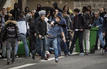 Varios estudiantes franceses que protestan por la reciente decisión gubernamental de deportar a una niña kosovar de etnia gitana, lanzan botellas a la policía antidisturbios en una manifestación en París (Francia), 17 de octubre de 2013. 