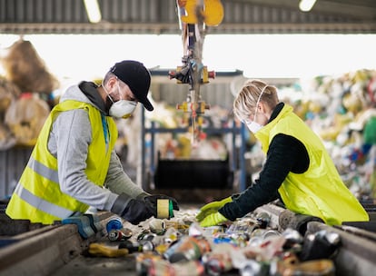 Dos empleados separan residuos para su reciclaje.
