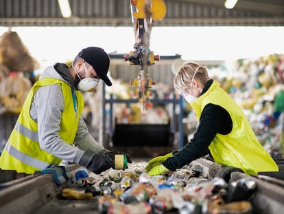 Dos empleados separan residuos para su reciclaje.