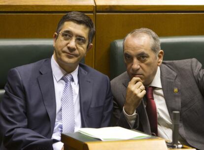 Patxi López, a la izquierda, e Iñaki Arriola conversan durante el pleno de ayer en el Parlamento vasco.