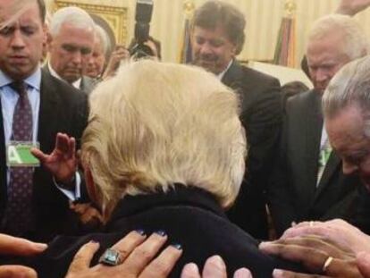 Varios pastores rezan sobre la espalda de Trump.
