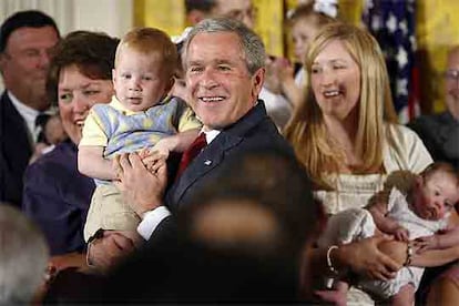 George Bush posa con bebés tras hablar contra el uso de células madre.