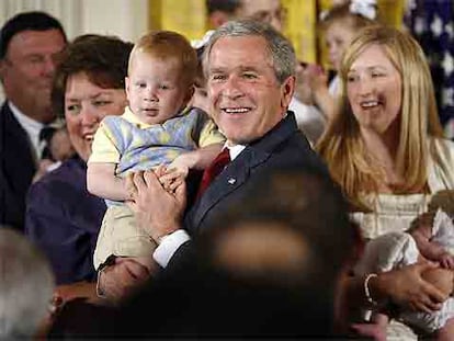 George Bush posa con bebés tras hablar contra el uso de células madre.