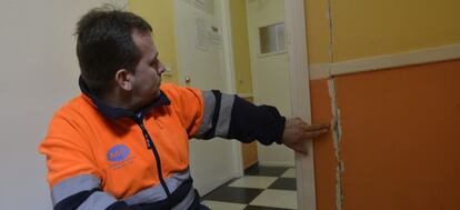Un trabajador del centro de salud de Torreperogil (Jaén) señala una grieta abierta en una pared.