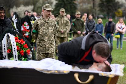 El soldado Hlib Kihitov, de 21 años, aguarda mientras su padre se despide de su hermano gemelo, Yegor, muerto en un bombardeo cerca de Popasna (sudeste), durante su funeral, celebrado en Lviv (oeste).