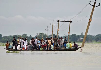 Unos aldeanos utilizan un barco para cruzar un camino inundado de Asigarh (India).