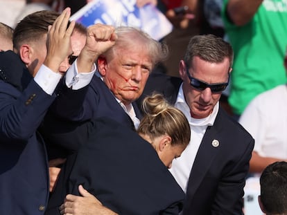 Donald Trump con sangre en el rostro es retirado por agentes de seguridad.