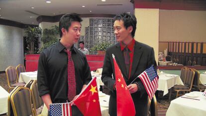 <b>Tom Xia (izquierda), en un restaurante chino de EE UU, compartiendo los fastos de celebración por el 60º aniversario de la revolución comunista.</b>