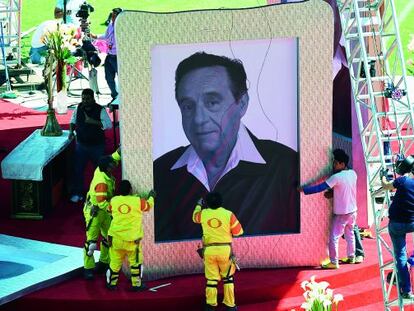 Trabajadores manipulan un retrato de Chespirito, en un tributo en honor del actor tras su muerte.