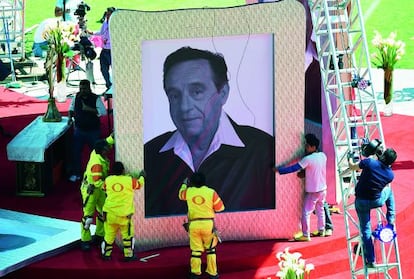 Trabajadores manipulan un retrato de Chespirito, en un tributo en honor del actor tras su muerte.