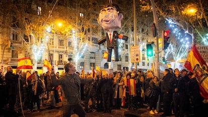 Un ciudadano apalea un muñeco de Sánchez, la pasada Nochevieja, cerca de la sede del PSOE.