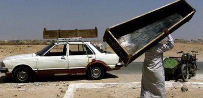 Un hombre transporta un ataúd tras el funeral de una madre y de una hija muertas en un atentado con coche-bomba en Irak en 2003