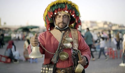 Un aguador posa para los turistas al atardecer en la plaza Djemaa el Fna.