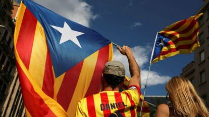 Un hombre sostiene una bandera estelada durante la diada de 2017.