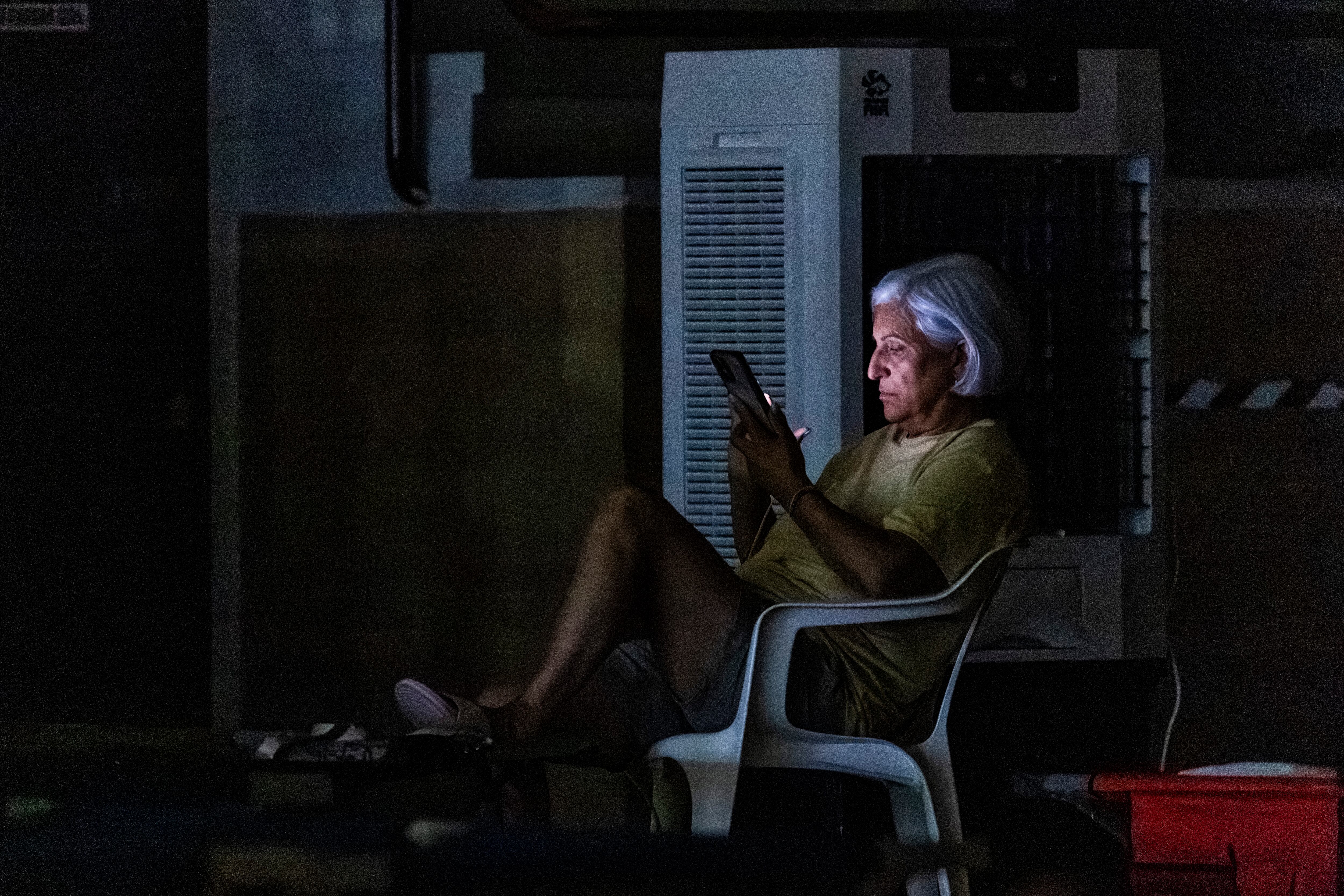 Una mujer mira el móvil en el polideportivo de La Bañeza.