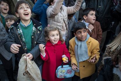 Niños esperan ilusionados que los Reyes Magos les tiren caramelos desde sus carrozas en Granada. 