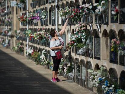 Una dona diposita flors al cementiri del Poblenou a Barcelona.