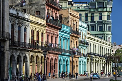 Turistas bajo los coloridos edificios con columnas en sus soportales en La Habana.