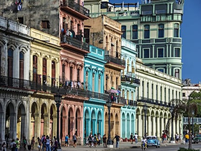 Turistas bajo los coloridos edificios con columnas en sus soportales en La Habana.
