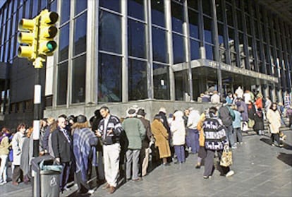 Clientes del Banco de la Republica hacen cola antes de que vuelvan a abrir los bancos en Montevideo.