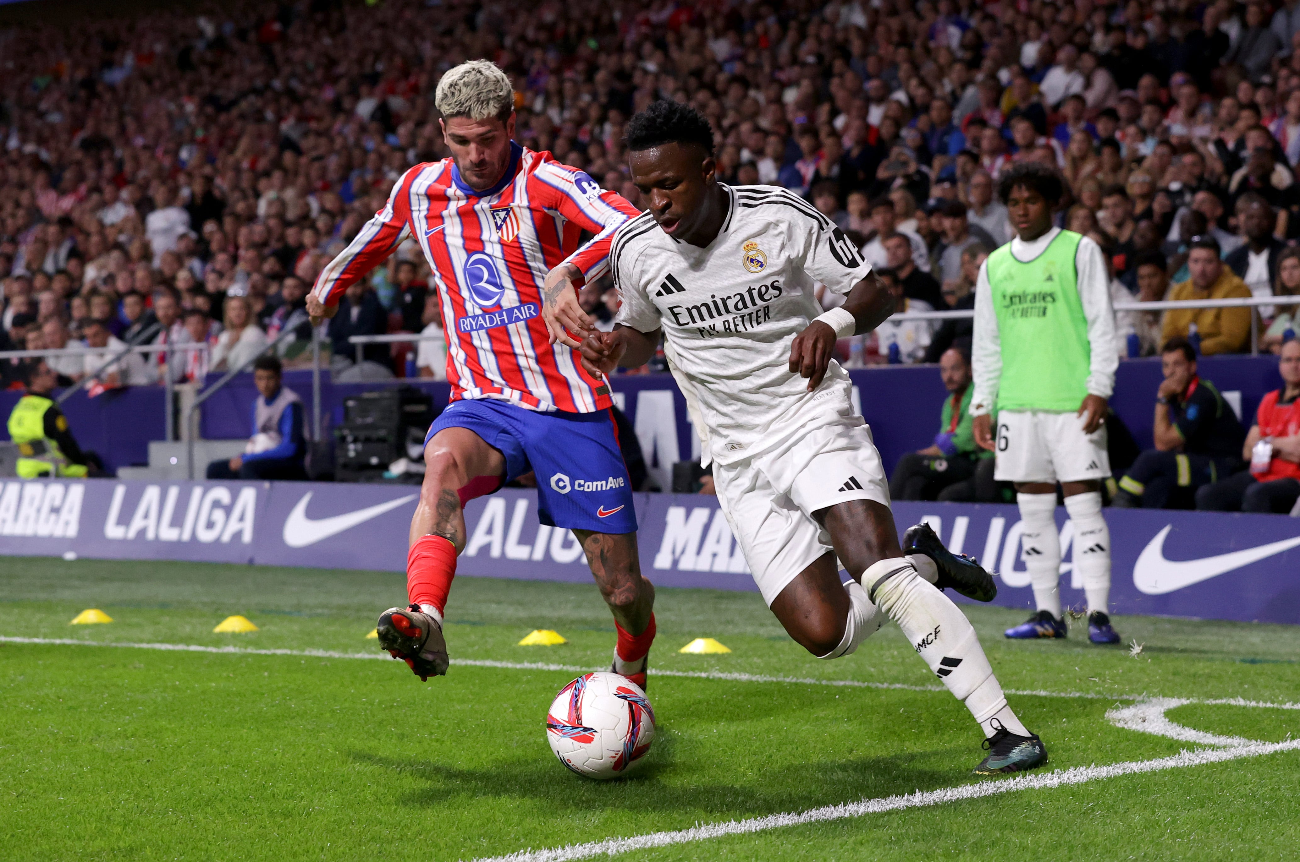 Rodrigo De Paul, jugador del Atlético de Madrid, pugna un balón con el futbolista del Real Madrid, Vinícius Junior.