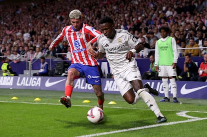 Rodrigo De Paul, jugador del Atlético de Madrid, pugna un balón con el futbolista del Real Madrid, Vinícius Junior.