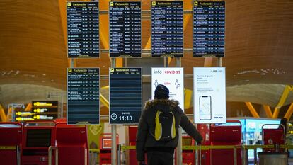 Un pasajero en el panel de salidas del aeropuerto de Barajas (Madrid), en diciembre.