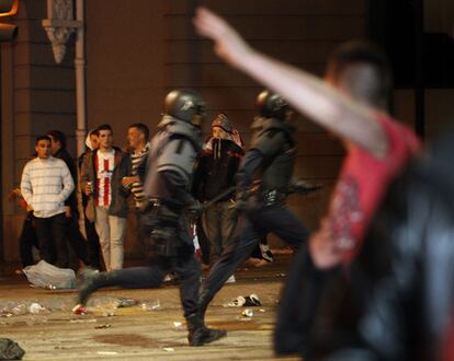 Miembros de la Policía Nacional desalojan a seguidores del Atlético de Madrid de las inmediaciones de la fuente de Neptuno.