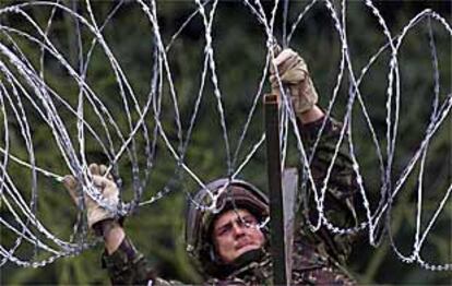 Un ingeniero del Ejército británico tiende una alhambrada en Dumcree, Portadown, para evitar la entrada de los orangistas en el distrito católico.