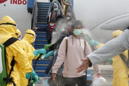 Personal sanitario desinfecta el pasado domingo en el aeropuerto Hang Nadim de Batam (Indonesia) a pasajeros de un vuelo procedente de zonas de China afectadas por el coronavirus de Wuhan.