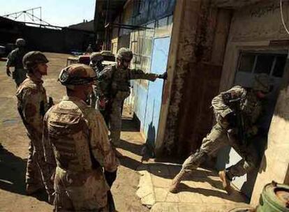 Soldados estadounidenses e iraquíes irrumpen en un taller sospechoso de fabricar bombas, ayer en Bagdad.
