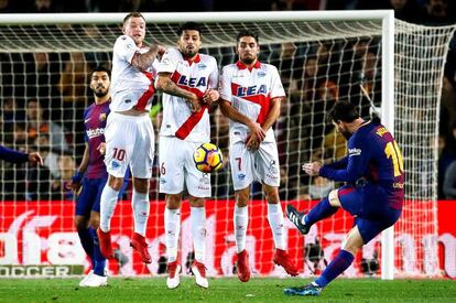 El delantero argentino del Barcelona Lionel Messi (d) intenta superar la barrera del Alavés durante el partido de la vigésimo primera jornada del Campeonato Nacional de Liga de futbol que se disputa en el estadio Camp Nou.