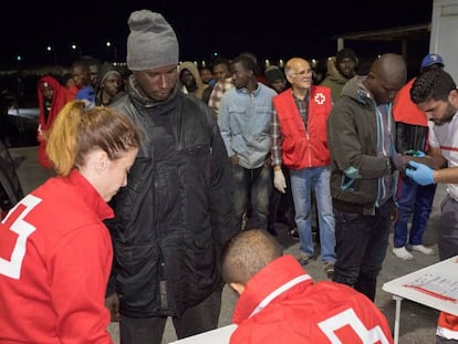 Trabajadores de la Cruz Roja reciben en el puerto de Motril (Granada) a un grupo de migrantes.