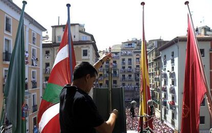 Un miembro de la pirotecnia valenciana de Caballer coloca el cohete en el balcón del Ayuntamiento de Pamplona.