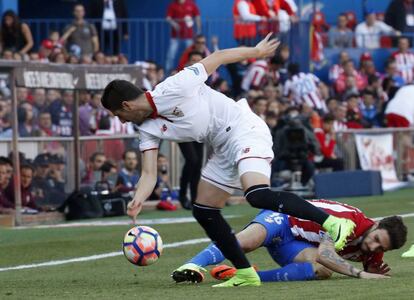El defensa croata del Atlético de Madrid Sime Vrsaljko disputa un balón con el jugador del Sevilla Sergio Escudero.